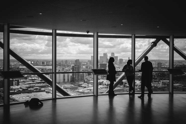 Silhouettes in observation deck overlooking city skyline